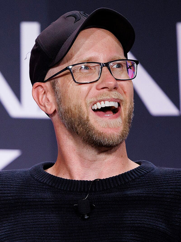 Man wearing a black cap and glasses with a dark background