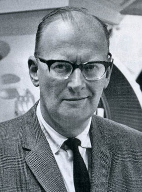 Black and white photo of a man wearing glasses and a suit.