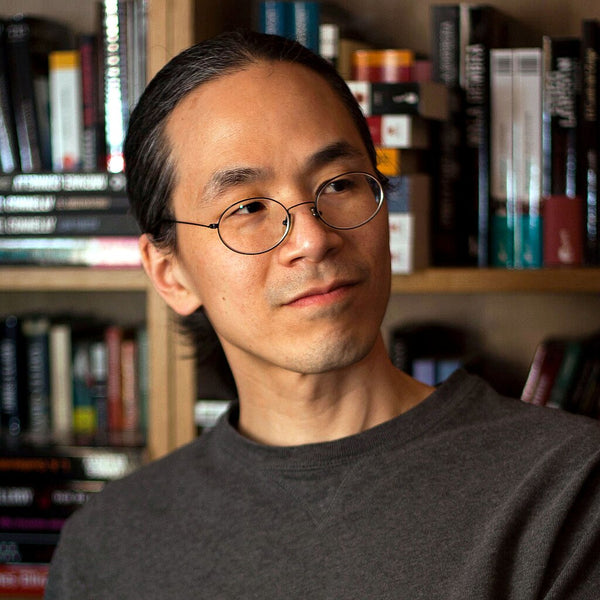 Man with glasses standing in front of a bookshelf