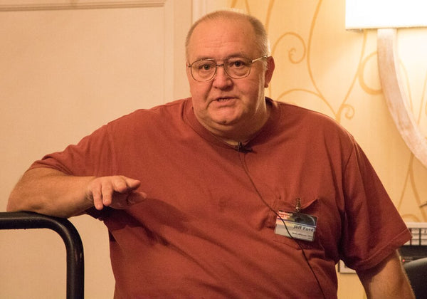 Man wearing a red shirt with a name tag in an indoor setting