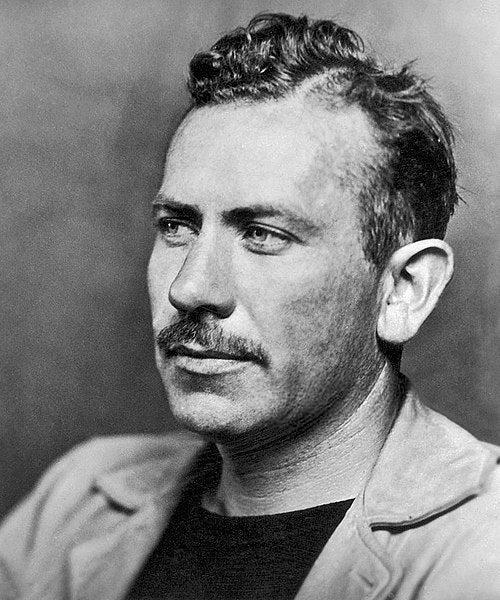 Black and white portrait of a man with a mustache and styled hair.