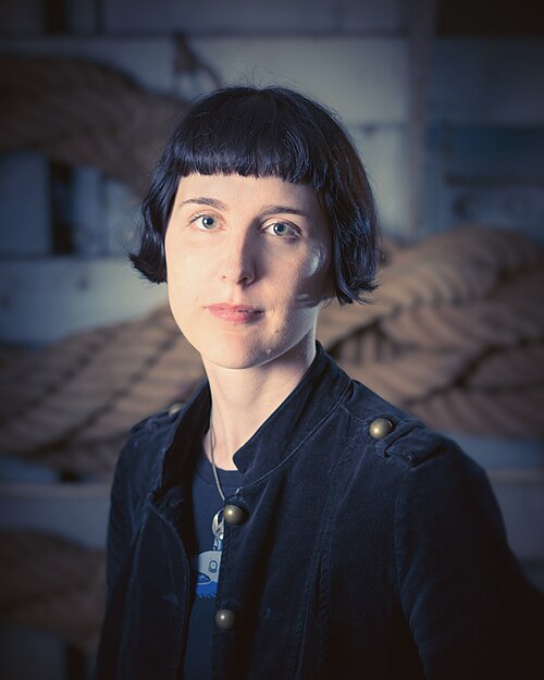 Person wearing a dark coat with a blurred background