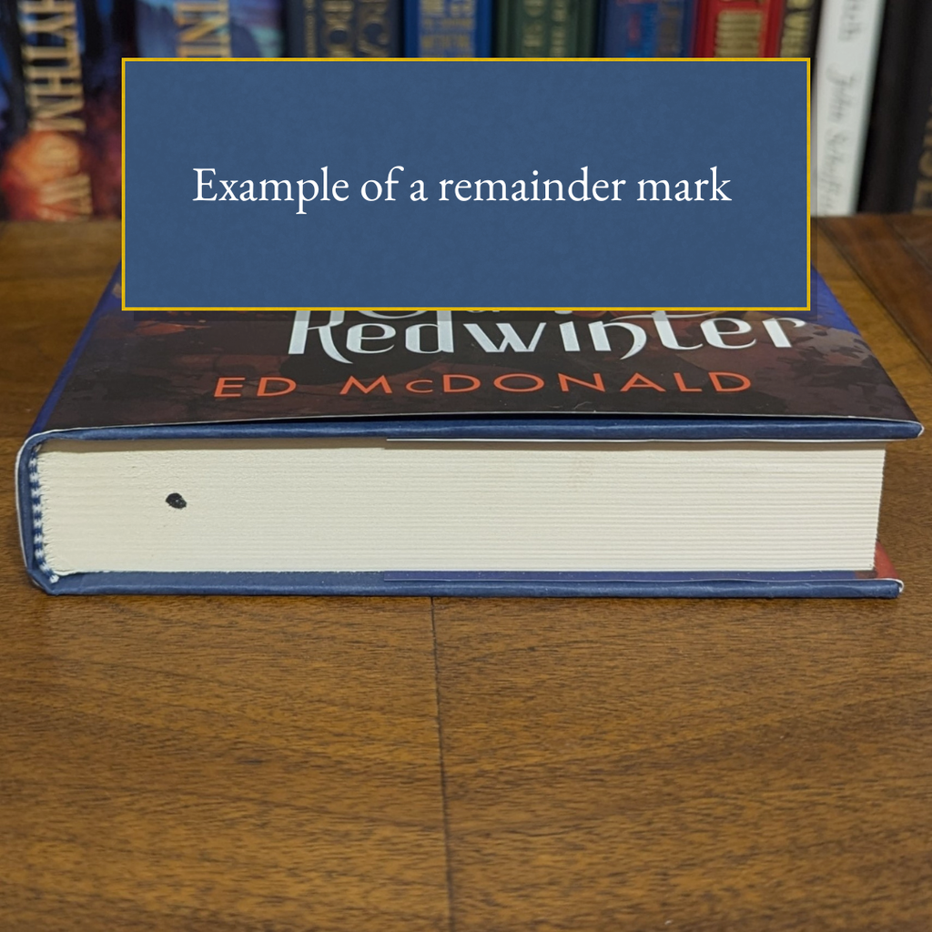 Book with a blue label indicating a remainder mark on a wooden surface.