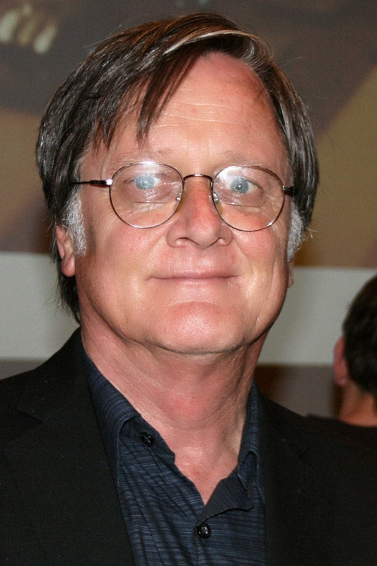 Man wearing glasses and a dark suit with a blurred background
